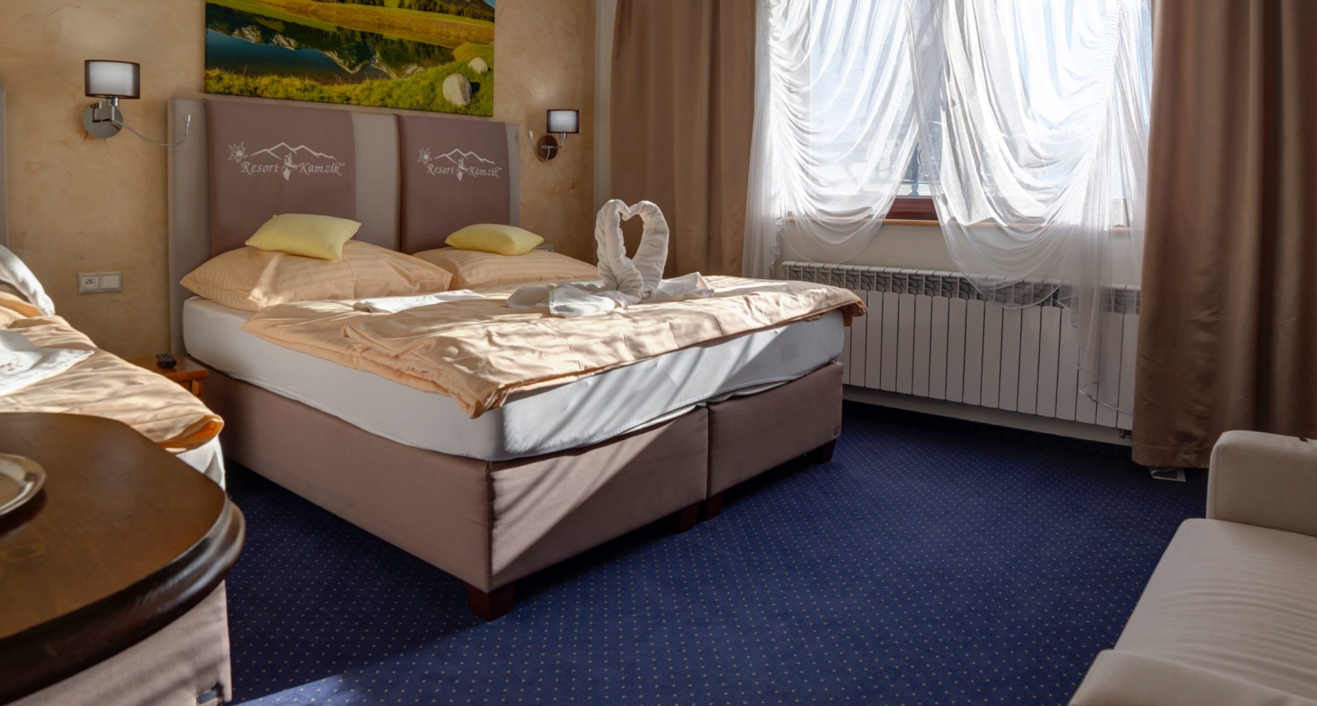 Klasyczny pokój hotelowy z dwoma łóżkami tapicerowanymi, wezgłowiami i eleganckim wyposażeniem dla gości