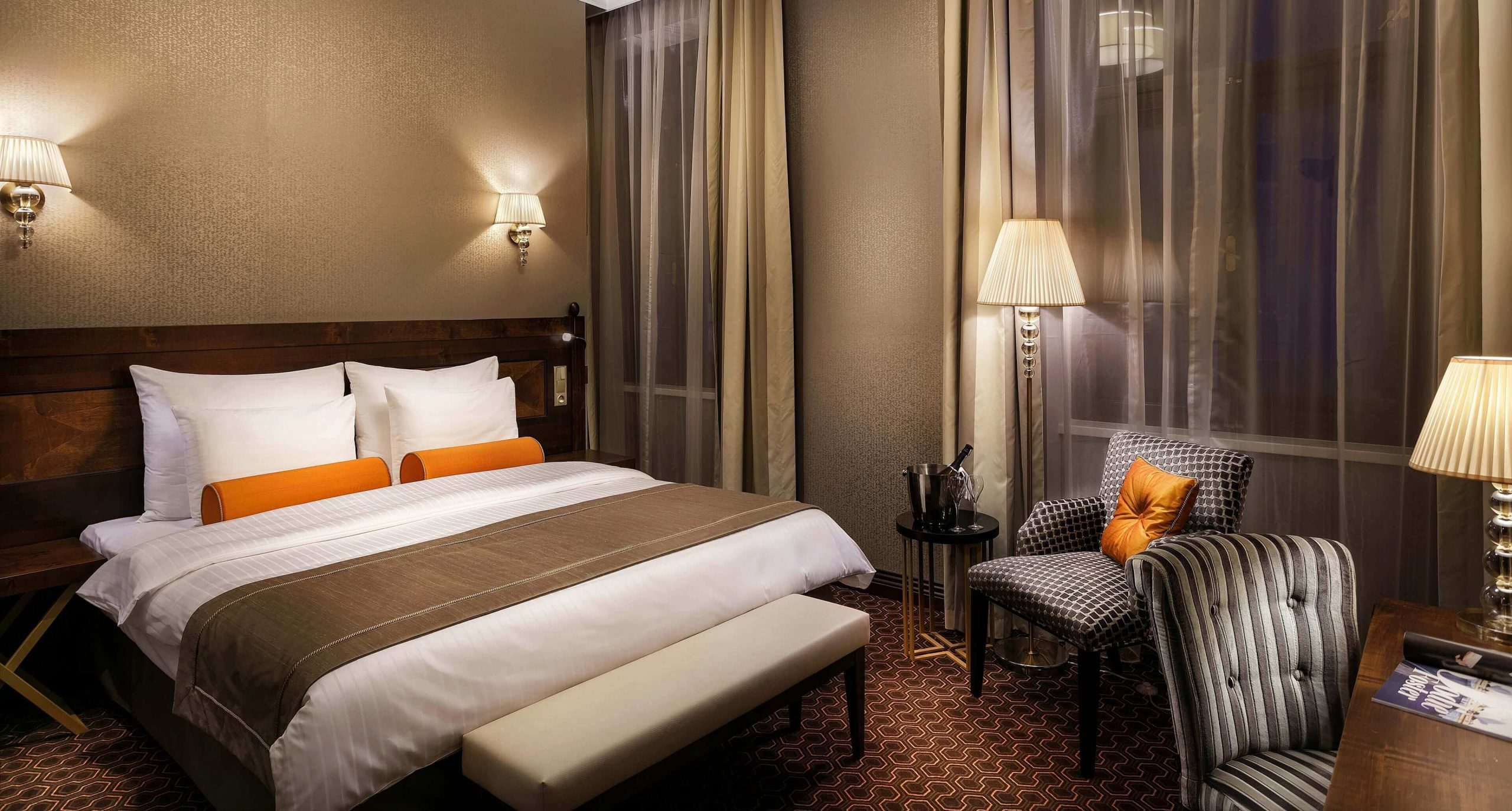 Dominantou hotelovej spálne je elegantná posteľ s čalúneným čelom.