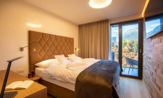 Moderní hotelový pokoj s manželskou postelí a výběrem polštářů pro kvalitní spánek hostů