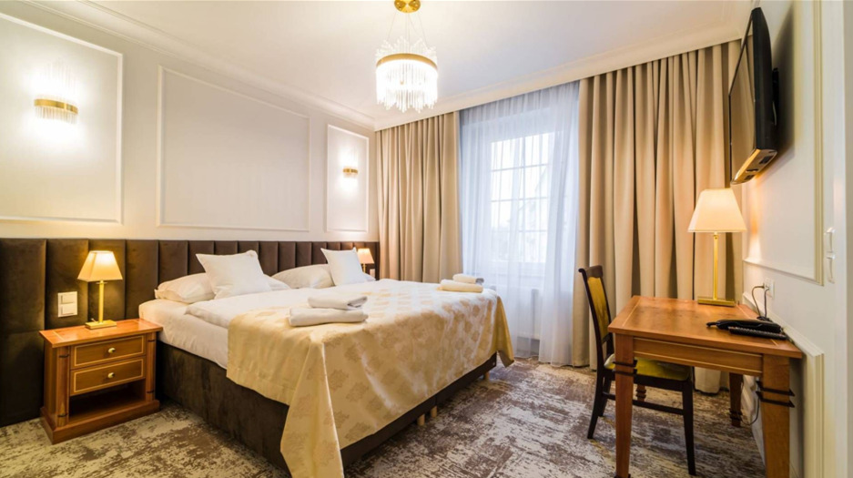 Elegantní hotelový pokoj s manželskou postelí, kvalitními lůžkovinami je pečlivě připravený spaní