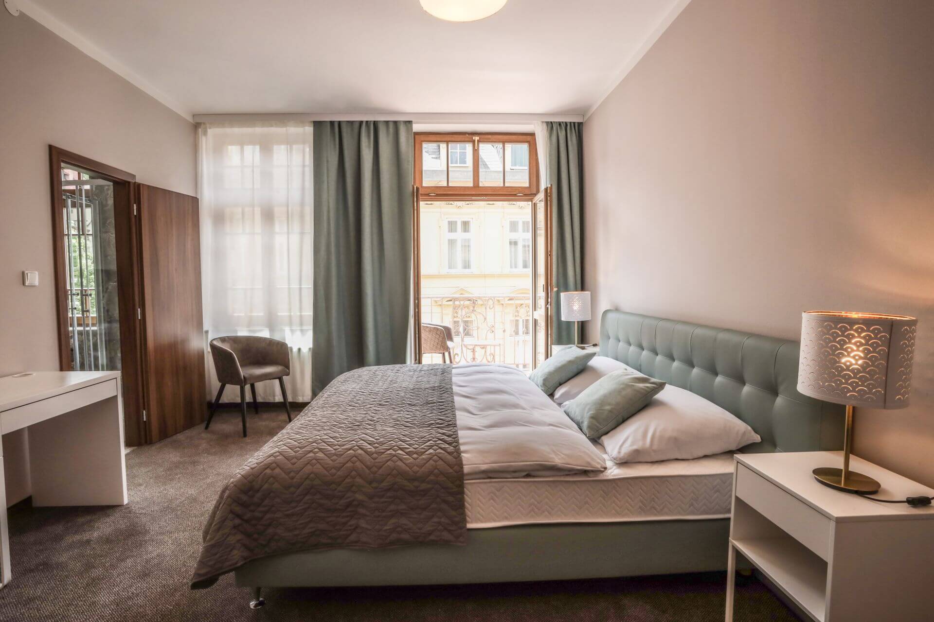 Hotelový pokoj s manželskou postelí, balkonem a zatemňovacími závěsy