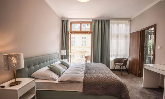 Moderní hotelový pokoj s kvalitní postelí, tlumeným osvětlením a závěsy pro nerušený spánek