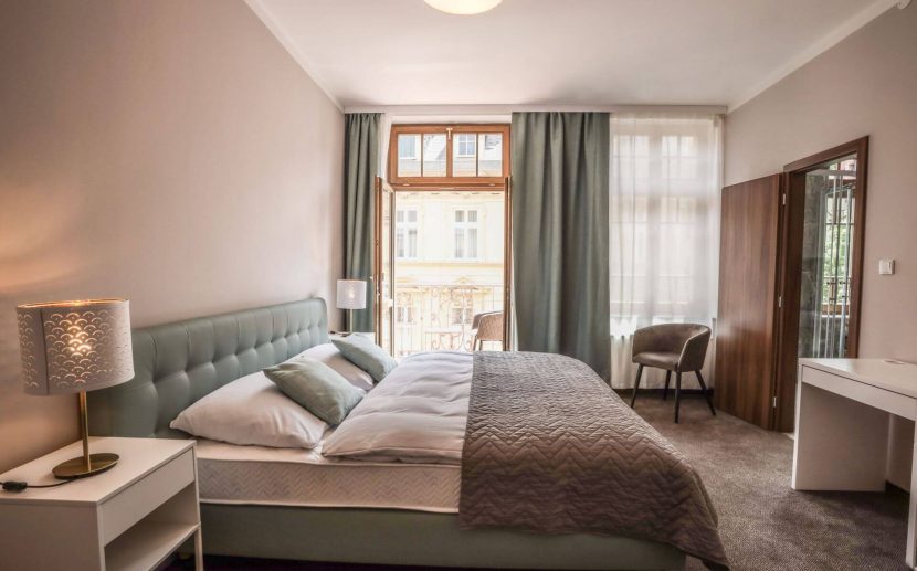 Moderní hotelový pokoj s kvalitní postelí, tlumeným osvětlením a závěsy pro nerušený spánek